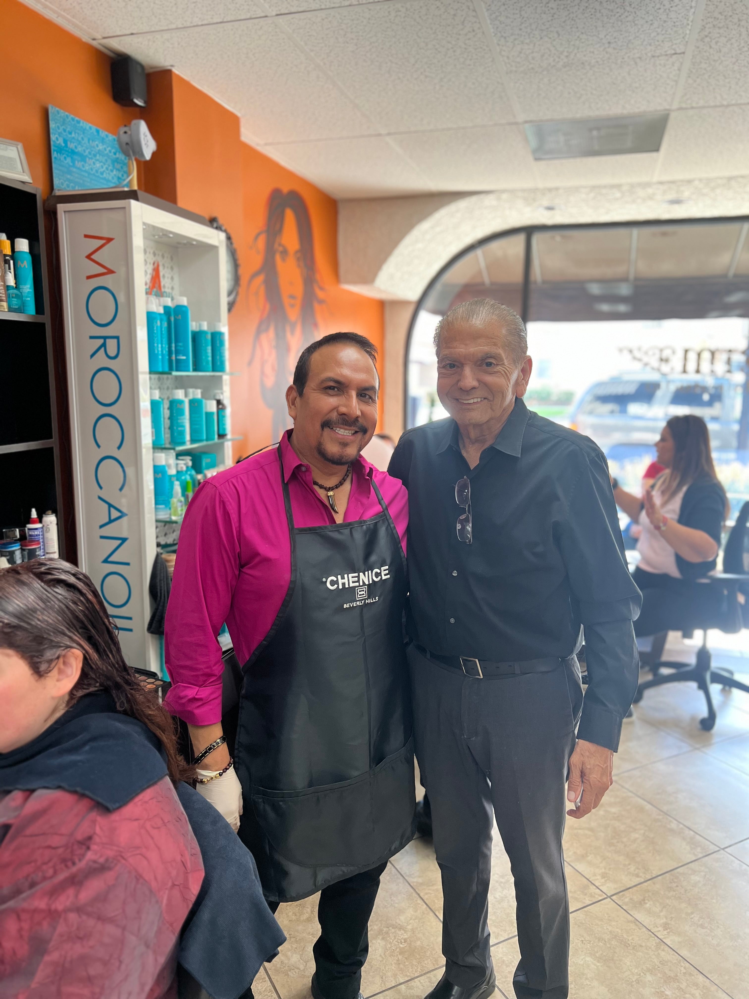 Two men standing inside a hair salon with 'Chenice Beverly Hills' on Ivan Montero apron.